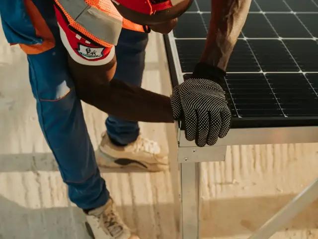 Someone installing a solar panel on a roof